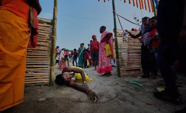 An Indian Hindu devotee prostrates and performs rituals on his way to the River Brahmaputra during the Chhath Puja festival in Guwahati, India, Monday, Oct. 27, 2025. (AP Photo/Anupam Nath)