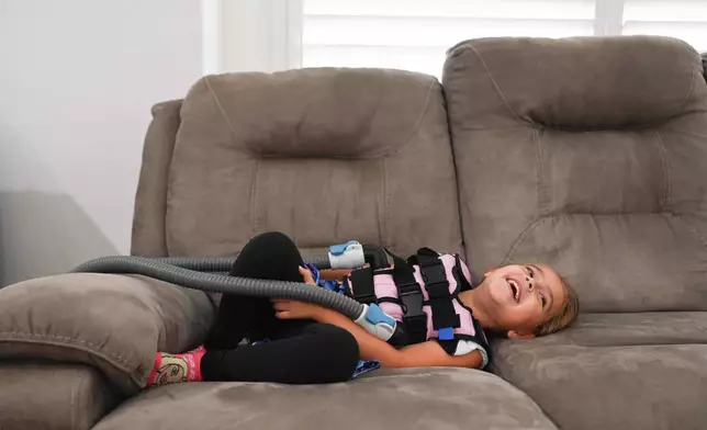 Amelia Bittner, 6, uses her vibrating CPT vest at her home on Wednesday, Oct. 29, 2025, in Pflugerville, Texas. (AP Photo/Jack Myer)