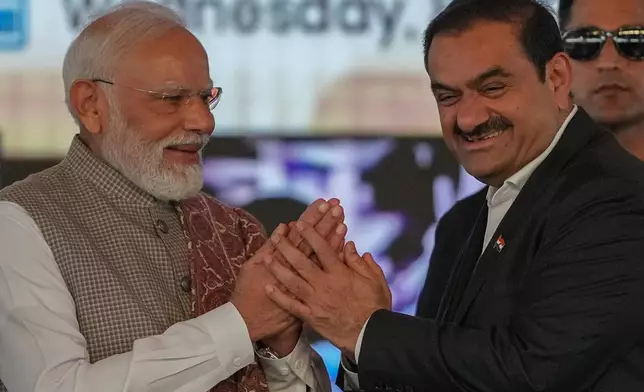 Indian Prime Minister Narendra Modi, left, greets Chairman Adani Group, Gautam Adani during the inauguration ceremony of the Navi Mumbai International Airport in Navi Mumbai, India, Wednesday, Oct. 8, 2025. (AP Photo/Rafiq Maqbool)
