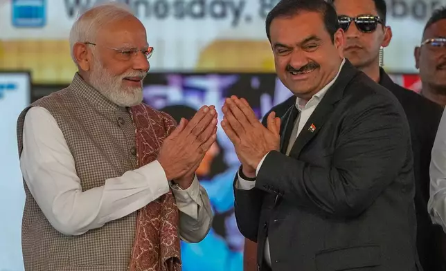 Indian Prime Minister Narendra Modi, left, greets Chairman Adani Group, Gautam Adani during the inauguration ceremony of the Navi Mumbai International Airport in Navi Mumbai, India, Wednesday, Oct. 8, 2025. (AP Photo/Rafiq Maqbool)
