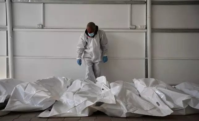 Bodies of unidentified Palestinians returned from Israel as part of the ceasefire deal are placed at a warehouse in Nasser Hospital in Khan Younis, Gaza Strip, Friday, Oct. 31, 2025. (AP Photo/Abdel Kareem Hana)