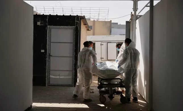 Bodies of unidentified Palestinians returned from Israel as part of the ceasefire deal are placed at a warehouse in Nasser Hospital in Khan Younis, Gaza Strip, Friday, Oct. 31, 2025. (AP Photo/Abdel Kareem Hana)