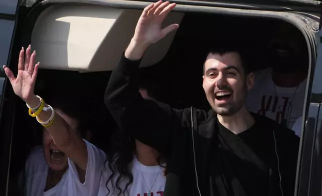 Freed Israeli hostage Guy Gilboa-Dalal gestures from a van as he arrives at Beilinson hospital in Petah Tikva, Israel, after he was released from Hamas captivity in the Gaza Stripl, Monday, Oct. 13, 2025. (AP Photo/Ariel Schalit)