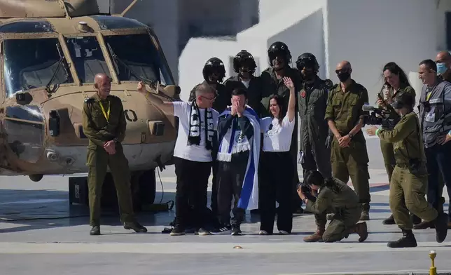 Matan Angrest, an Israeli hostage released from the Gaza Strip puts his hands on his face after coming off a helicopter at the Ichilov Hospital, in Tel Aviv, Israel, Monday, Oct. 13, 2025. (AP Photo/Ohad Zwigenberg)