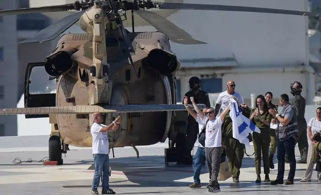 Omri Miran, an Israeli hostage released from the Gaza Strip waves an Israeli flag after coming off a helicopter at the Ichilov Hospital, in Tel Aviv, Israel, Monday, Oct. 13, 2025. (AP Photo/Ohad Zwigenberg)