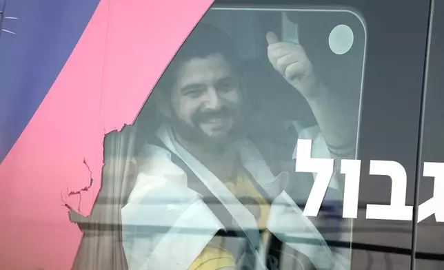 Ziv Berman, an Israeli hostage released from the Gaza Strip gestures from a minibus at the Sheba Medical Center in Ramat Gan, Israel, Monday, Oct. 13, 2025. (AP Photo/Leo Correa)