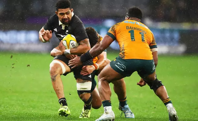 New Zealand's Ardie Savea, left, runs at Australia's Filipo Daugunu during the Bledisloe Cup rugby test between the All Blacks and the Wallabies in Perth, Australia, Saturday, Oct 4, 2025. (AP Photo/Gary Day)