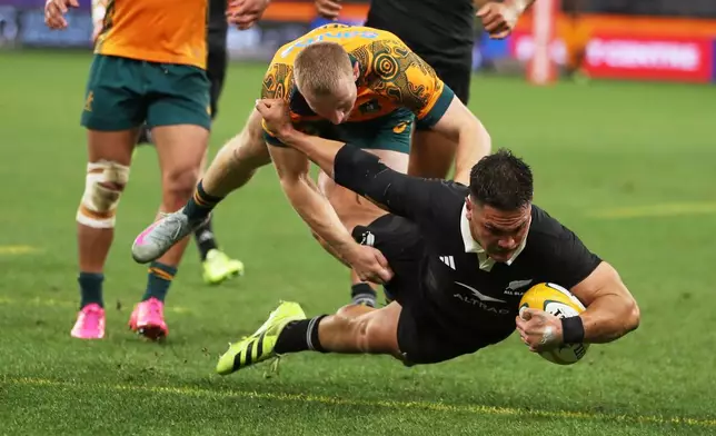 New Zealand's Quinn Tupaea dives over the line to score a try in the tackle of Australia's Australia's Max Jorgensen during the Bledisloe Cup rugby test between the All Blacks and the Wallabies in Perth, Australia, Saturday, Oct 4, 2025. (AP Photo/Gary Day)