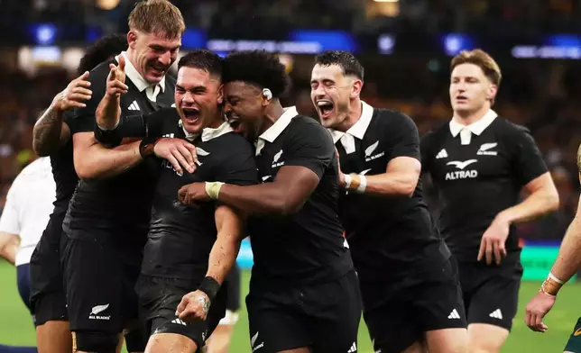 New Zealand's Quinn Tupaea, second left, is congratulated by teammates after scoring a try during the Bledisloe Cup rugby test between the All Blacks and the Wallabies in Perth, Australia, Saturday, Oct 4, 2025. (AP Photo/Gary Day)