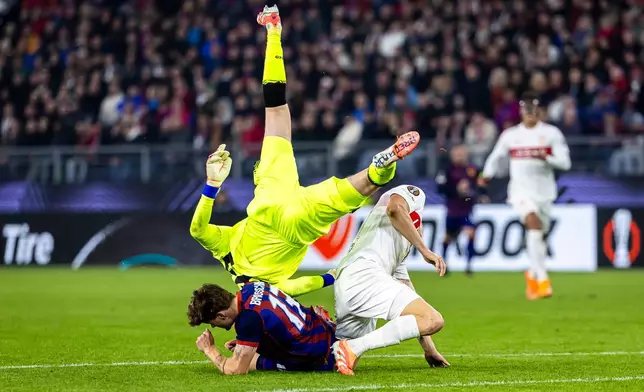 VfB Stuttgart's goalkeeper Alexander Nuebel, top, clashes with FC Basel's Moritz Broschinski, left, and Stuttgart's Ramon Hendriks during the Europa League soccer match between FC Basel and VfB Stuttgart at the St. Jakob-Park stadium in Basel, Switzerland, Thursday Oct. 2, 2025. (Michael Buholzer/Keystone via AP)
