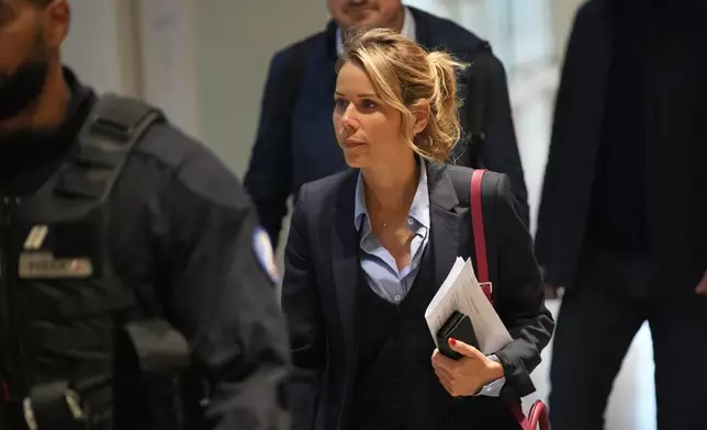 Tiphaine Auziere, daughter of Brigitte Macron, arrives as a courtroom as ten people go on trial accused of cyberbullying Brigitte Macron after they allegedly made "malicious" comments online spreading claims that President Emmanuel Macron's wife is a man, Tuesday, Oct. 28, 2025 in Paris. (AP Photo/Christophe Ena)