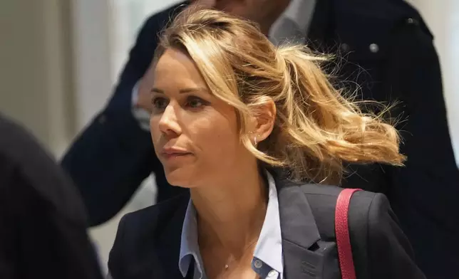 Tiphaine Auziere, daughter of Brigitte Macron, arrives as a courtroom as ten people go on trial accused of cyberbullying Brigitte Macron after they allegedly made "malicious" comments online spreading claims that President Emmanuel Macron's wife is a man, Tuesday, Oct. 28, 2025 in Paris. (AP Photo/Christophe Ena)