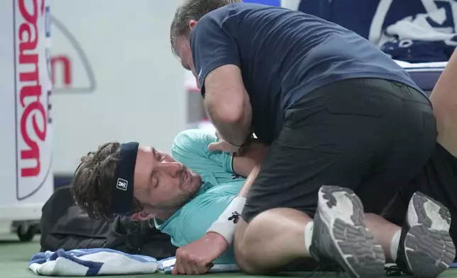 Arthur Rinderknech of France is attended to by a trainer, as he plays against Valentin Vacherot of Monaco during the final of the Shanghai Masters tennis tournament at Qizhong Forest Sports City Tennis Center, in Shanghai, China, Sunday, Oct. 12, 2025. (AP Photo/Andy Wong)