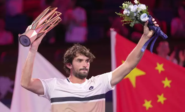 Valentin Vacherot of Monaco celebrates with the trophy after winning the final of the Shanghai Masters tennis tournament defeating Arthur Rinderknech of France at Qizhong Forest Sports City Tennis Center, in Shanghai, China, Sunday, Oct. 12, 2025. (AP Photo/Andy Wong)