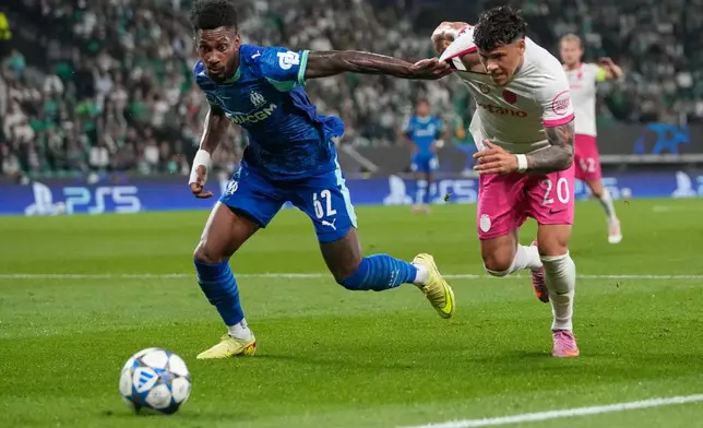 Marseille's Michael Murillo, left, challenges for the ball with Sporting's Maximiliano Araujo during the Champions League opening phase soccer match between Sporting CP and Marseille in Lisbon, Portugal, Wednesday, Oct. 22, 2025. (AP Photo/Armando Franca)