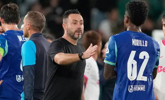 Marseille's head coach Roberto De Zerbi greets Michael Murillo after the Champions League opening phase soccer match between Sporting CP and Marseille in Lisbon, Portugal, Wednesday, Oct. 22, 2025. (AP Photo/Armando Franca)