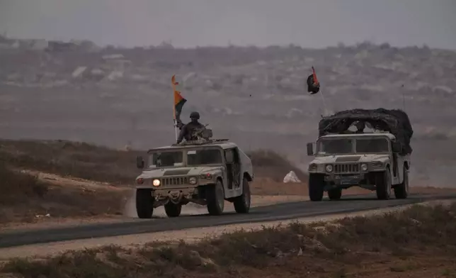Israeli soldiers move near the Israeli-Gaza border, as seen from southern Israel, Thursday, Oct. 9, 2025, following the announcement that Israel and Hamas have agreed to the first phase of a peace plan to pause the fighting. (AP Photo/Ariel Schalit)