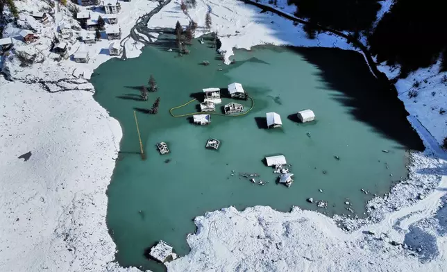 An aerial view shows the partly flooded village of Blatten after recent snowfalls, five months after a landslide destroyed the village, Blatten, Switzerland, on Tuesday, Oct. 28, 2025. (AP Photo/Michael Probst)