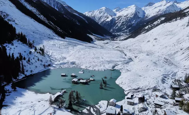 An aerial view shows the partly flooded village of Blatten after recent snowfalls, five months after a landslide destroyed the village, Blatten, Switzerland, on Tuesday, Oct. 28, 2025. (AP Photo/Michael Probst)
