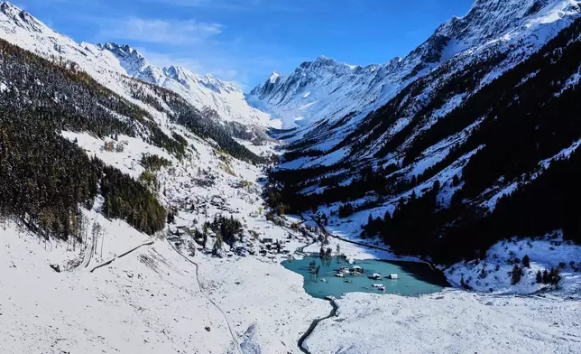 An aerial view shows the partly flooded village of Blatten after recent snowfalls, five months after a landslide destroyed the village, Blatten, Switzerland, on Tuesday, Oct. 28, 2025. (AP Photo/Michael Probst)