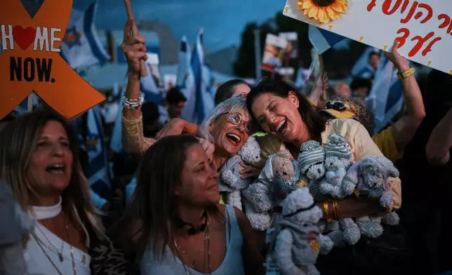 People gather prior to the release of Israeli hostages held in Gaza, at a plaza known as the hostages square in Tel Aviv, Israel, Monday, Oct. 13, 2025. (AP Photo/Emilio Morenatti)