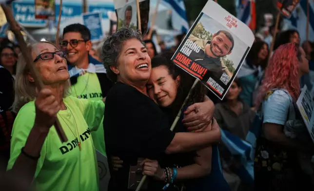 People gather prior to the release of Israeli hostages held in Gaza, at a plaza known as the hostages square in Tel Aviv, Israel, Monday, Oct. 13, 2025. (AP Photo/Emilio Morenatti)