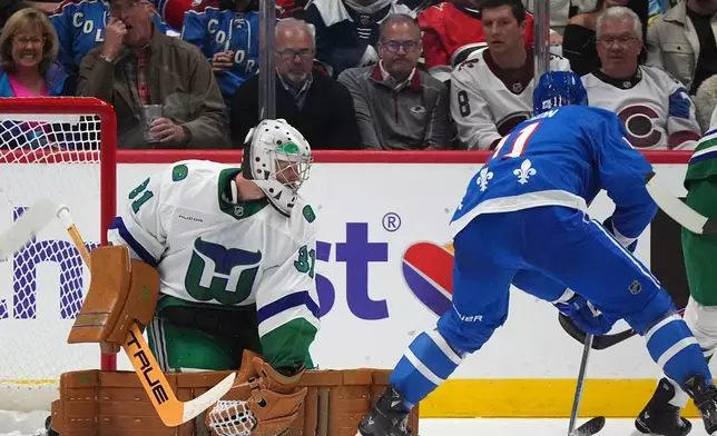 Carolina Hurricanes goaltender Frederik Andersen, left, deflects a shot from Colorado Avalanche center Brock Nelson in the second period of an NHL hockey game, Thursday, Oct. 23, 2025, in Denver. (AP Photo/David Zalubowski)