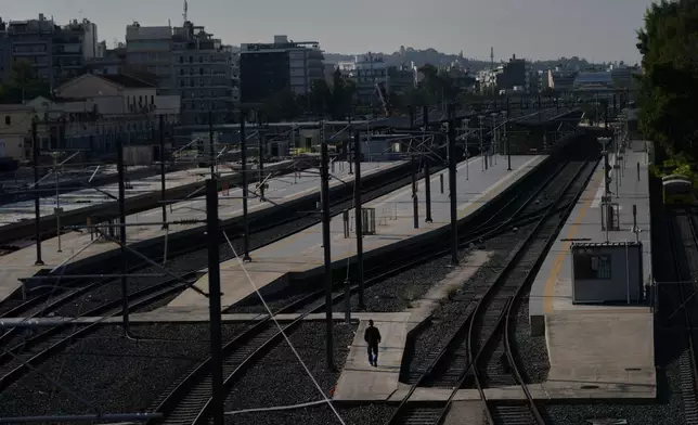 A man walks at the closed Greek capital's main railway station during a nationwide 24-hour strike in Athens, Greece, Tuesday, Oct. 14, 2025, as labor unions demand higher wages and the withdrawal of a bill changing work hours. (AP Photo/Petros Giannakouris)