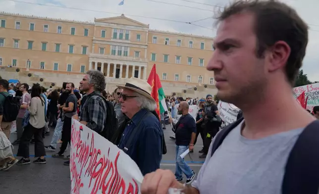 Protesters take part in a nationwide 24-hour strike in Athens, Greece, Tuesday, Oct. 14, 2025, as labor unions demand higher wages and the withdrawal of a bill changing work hours. (AP Photo/Petros Giannakouris)