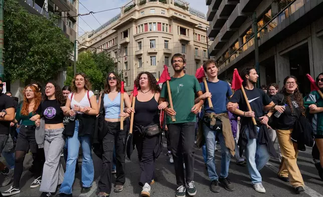 Protesters take part in a nationwide 24-hour strike in Athens, Greece, Tuesday, Oct. 14, 2025, as labor unions demand higher wages and the withdrawal of a bill changing work hours. (AP Photo/Petros Giannakouris)