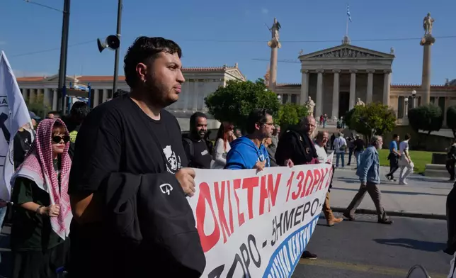 Protesters take part in a nationwide 24-hour strike in Athens, Greece, Tuesday, Oct. 14, 2025, as labor unions demand higher wages and the withdrawal of a bill changing work hours. (AP Photo/Petros Giannakouris)