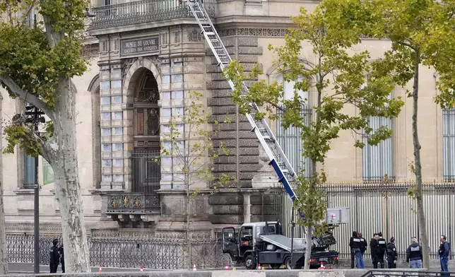 Police officers work by a basket lift used by thieves Sunday, Oct. 19, 2025 at the Louvre museum in Paris. (AP Photo/Thibault Camus)
