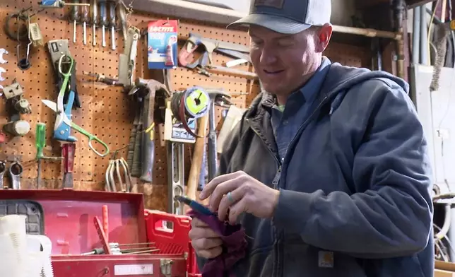 FILE - Bryant Kagay holds a tool in the workshop of the farm he co-owns with his father and grandfather in Amity, Missouri, April 4, 2025. (AP Photo/Nick Ingram, File)