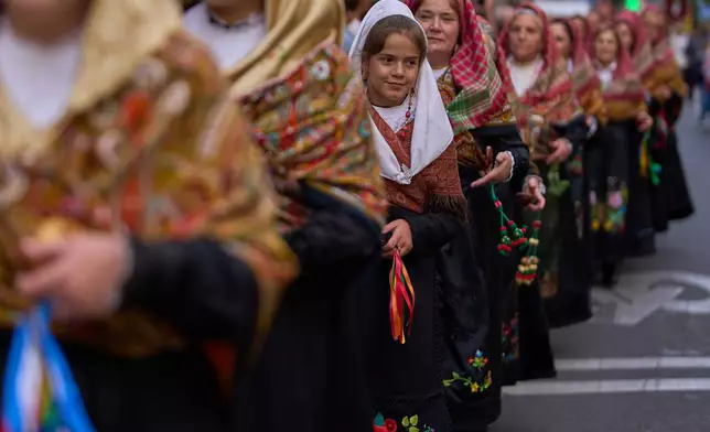 People in regional traditional costumes take part in the herding of sheep through central Madrid, Spain, as shepherds lead the animals through the streets in defense of ancient grazing and migration rights, Sunday, Oct. 19, 2025. (AP Photo/Manu Fernandez)