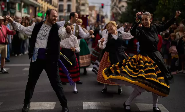 People in regional traditional costumes take part in the herding of sheep through central Madrid, Spain, as shepherds lead the animals through the streets in defense of ancient grazing and migration rights, Sunday, Oct. 19, 2025. (AP Photo/Manu Fernandez)