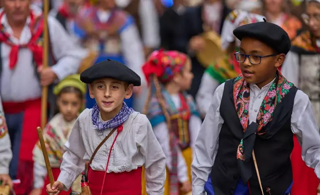 Young shepherds herd a flock of sheep through central Madrid, Spain, as shepherds lead the animals through the streets in defense of ancient grazing and migration rights, Sunday, Oct. 19, 2025. (AP Photo/Manu Fernandez)