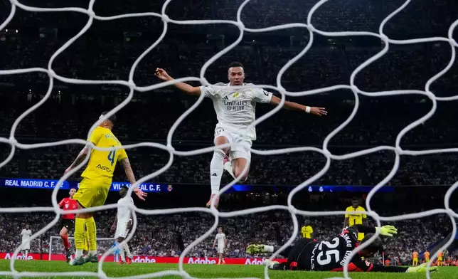 Real Madrid's Kylian Mbappe, centre, celebrates after scoring his side's third goal during the Spanish La Liga soccer match between Real Madrid and Villarreal at the Santiago Bernabeu stadium in Madrid, Spain, Saturday, Oct. 4, 2025. (AP Photo/Manu Fernandez)