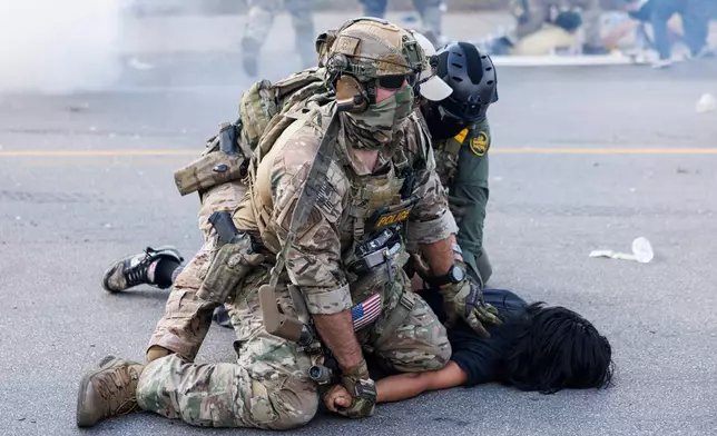 Federal officers hold down a protester in the Brighton Park neighborhood of Chicago, on Saturday, Oct. 4, 2025, after protesters learned that U.S. Border Patrol shot a woman Saturday morning on Chicago's Southwest Side. (Anthony Vazquez/Chicago Sun-Times via AP)