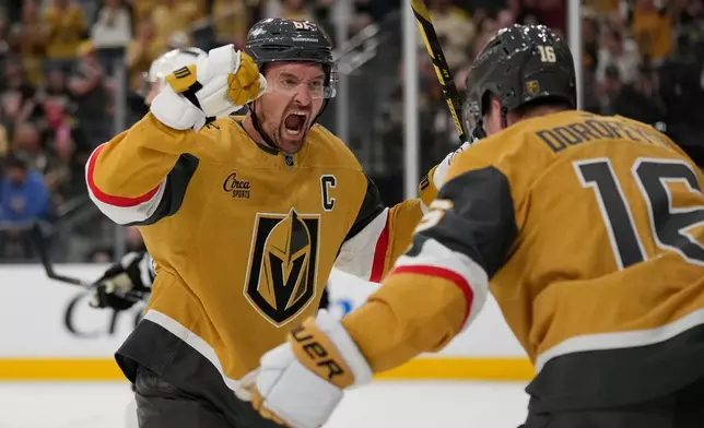 Vegas Golden Knights right wing Mark Stone (61) celebrates after Pavel Dorofeyev, right, scored against the Los Angeles Kings during the second period of an NHL hockey game Wednesday, Oct. 8, 2025, in Las Vegas. (AP Photo/John Locher)