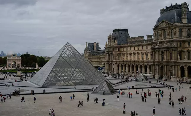 FILE - People walk outside the Louvre museum, Sunday, Aug. 31, 2025, in Paris. (AP Photo/Julia Demaree Nikhinson, File)