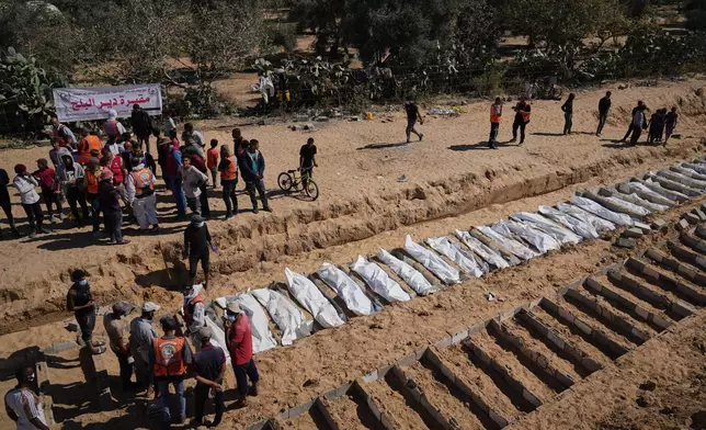 Bodies of unidentified Palestinians returned from Israel are buried in a mass grave in Deir al-Balah, Gaza Strip, Monday, Oct. 27, 2025. (AP Photo/Jehad Alshrafi)