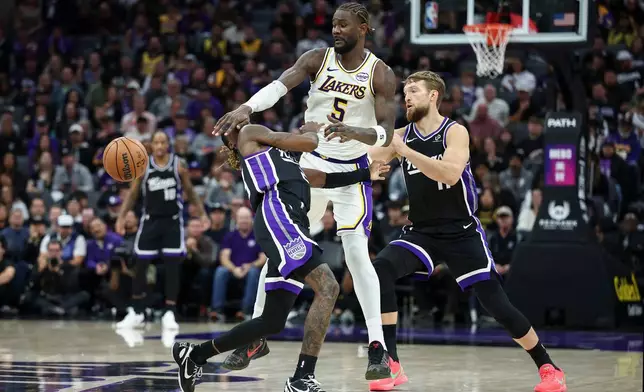 A flagrant foul is called on Los Angeles Lakers center Deandre Ayton, center, against Sacramento Kings guard Keon Ellis, left, during the second half of an NBA basketball game Sunday, Oct. 26, 2025, in Sacramento, Calif. (AP Photo/Sara Nevis)