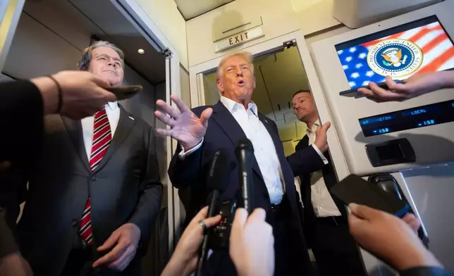 President Donald Trump, center, joined by Treasury Secretary Scott Bessent, left, and U.S. Trade Representative Jamieson Greer, right, speaks to reporters aboard Air Force One while traveling from Kuala Lumpur, Malaysia, to Tokyo, Japan, Monday, Oct. 27, 2025. (AP Photo/Mark Schiefelbein)