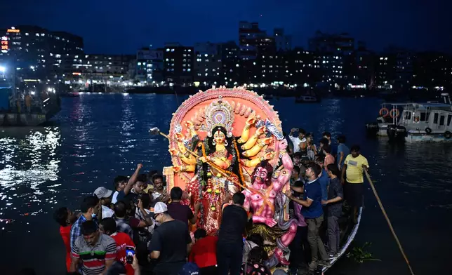 Devotees carry an idol of the Hindu goddess Durga in a boat for immersion in the Buriganga River marking the end of Durga Puja in Dhaka, Bangladesh, Thursday, Oct. 2, 2025. (AP Photo/Mahmud Hossain Opu)