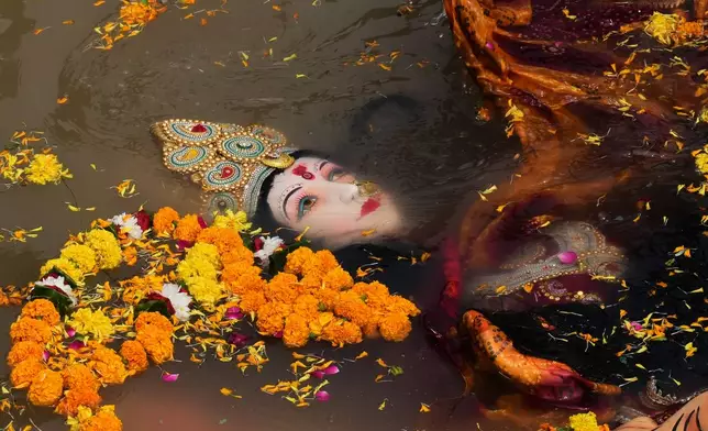 Devotees immerse an idol of Hindu goddess Durga in a makeshift water pit at the end of Durga Puja festival in New Delhi, India, Thursday, Oct. 2, 2025. (AP Photo/Manish Swarup)