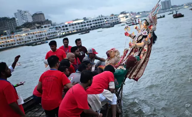 Devotees carry an idol of the Hindu goddess Durga in a boat for immersion in the Buriganga River marking the end of Durga Puja in Dhaka, Bangladesh, Thursday, Oct. 2, 2025. (AP Photo/Mahmud Hossain Opu)