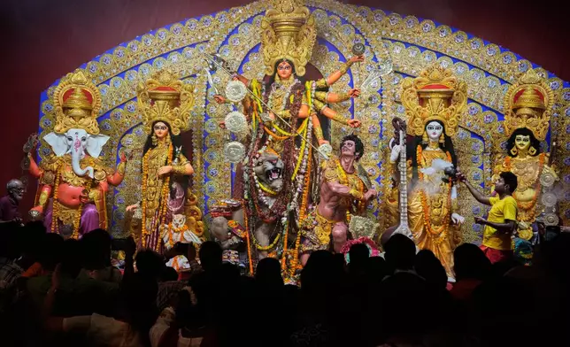 A priest worship an idol of goddess Durga on the second day of Hindu festival Durga Puja at a makeshift worsip venue, in Kolkata, India, Tuesday, Sept. 30, 2025. (AP Photo/Bikas Das)