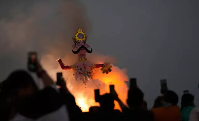 Indian people watch an effigy of demon king Ravana's son Meghnath go up in flames marking the end of Dussehra festival in Jammu, India, Thursday, Oct.2, 2025.(AP Photo/Channi Anand)