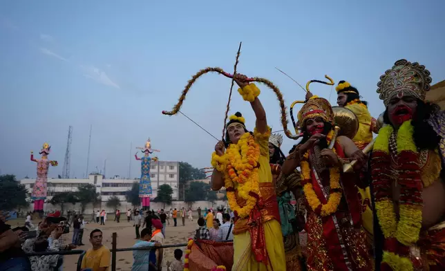 Artists dressed up as Hindu gods shout religious slogans during Dussehra festivities in Jammu, India, Thursday, Oct.2, 2025.(AP Photo/Channi Anand)