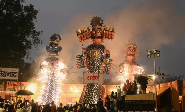 Effigies of demon king Ravana, centre, his son Meghnad and brother Kumbhkarna are set on fire, marking the end of Dussehra festival in New Delhi, India, Thursday, Oct. 2, 2025.(AP Photo/Deepanshu Aggarwal)